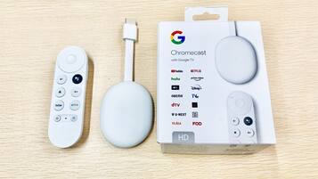 A Chromecast device, a USB cable, and a box with logos of various streaming services.