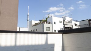 Ein modernes Gebäude mit flachem Dach und einer turmartigen Struktur im Hintergrund.