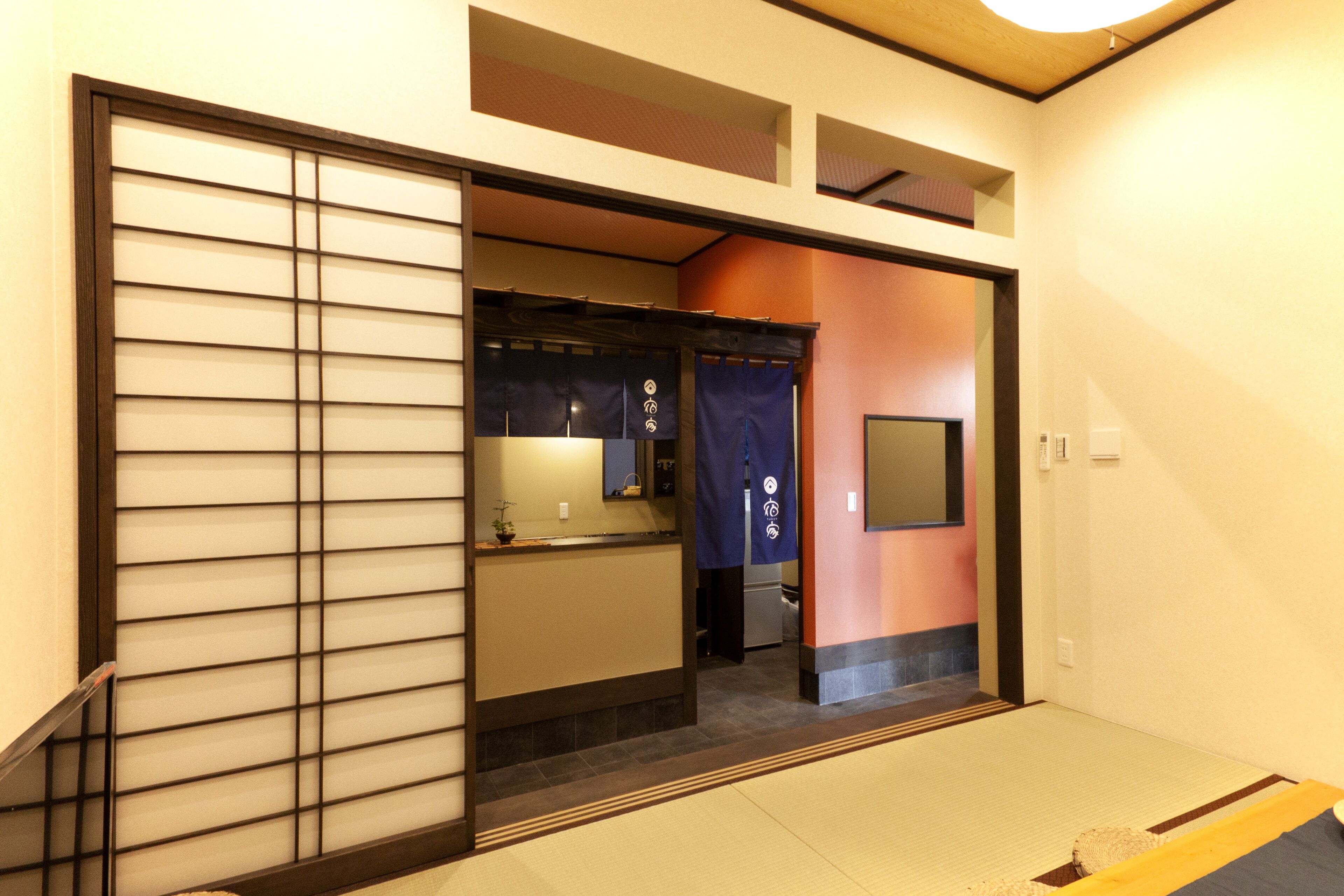 A traditional Japanese room with tatami flooring, a sliding door, and a small washbasin.