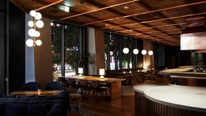 A modern restaurant with wooden ceiling beams, large windows, and a bar area. - The Knot Sapporo (Sapporo)