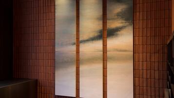 A wall with a vertical wooden panel design and a large, rectangular artwork.