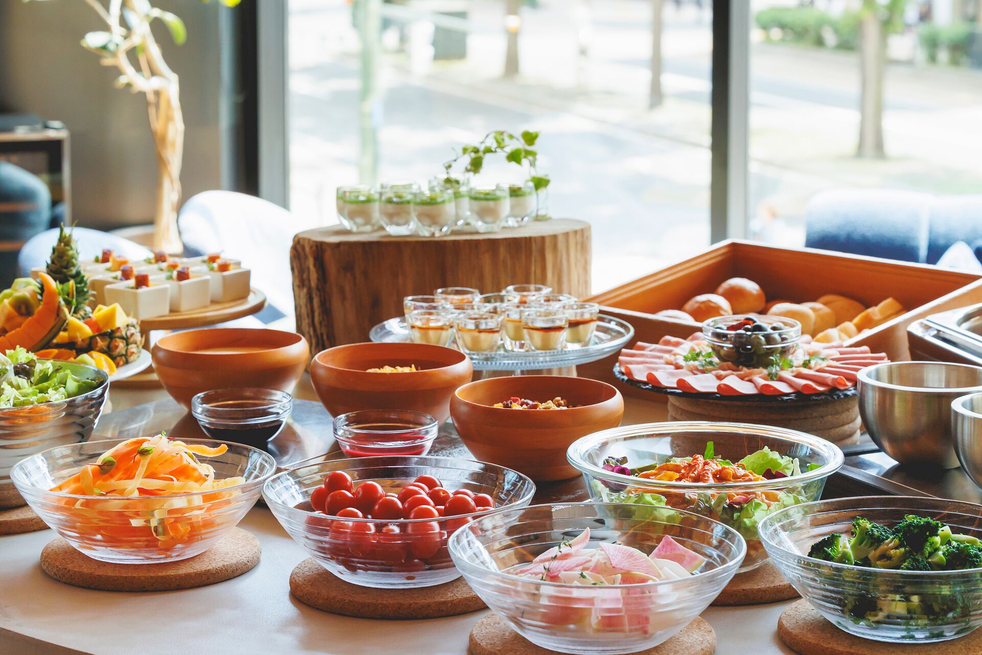 A buffet table with various food items including salads, fruits, and desserts.