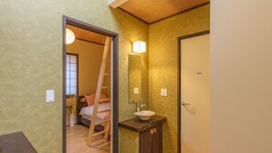 Un bagno con una scala in legno, un lavandino e uno specchio.