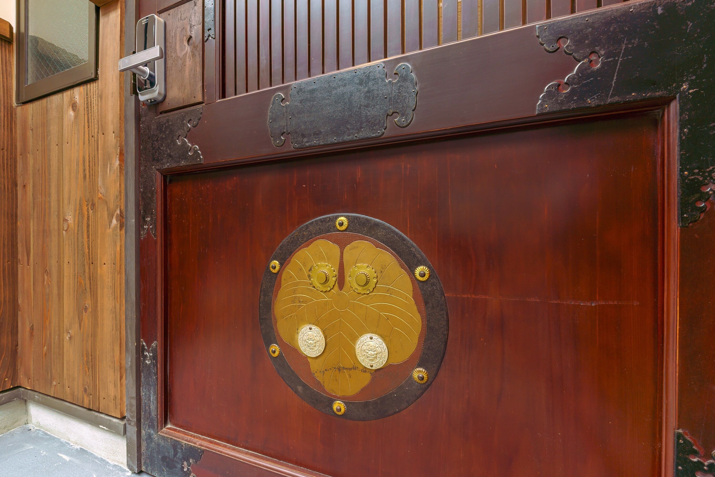 A wooden door with a brass plaque and a lock.