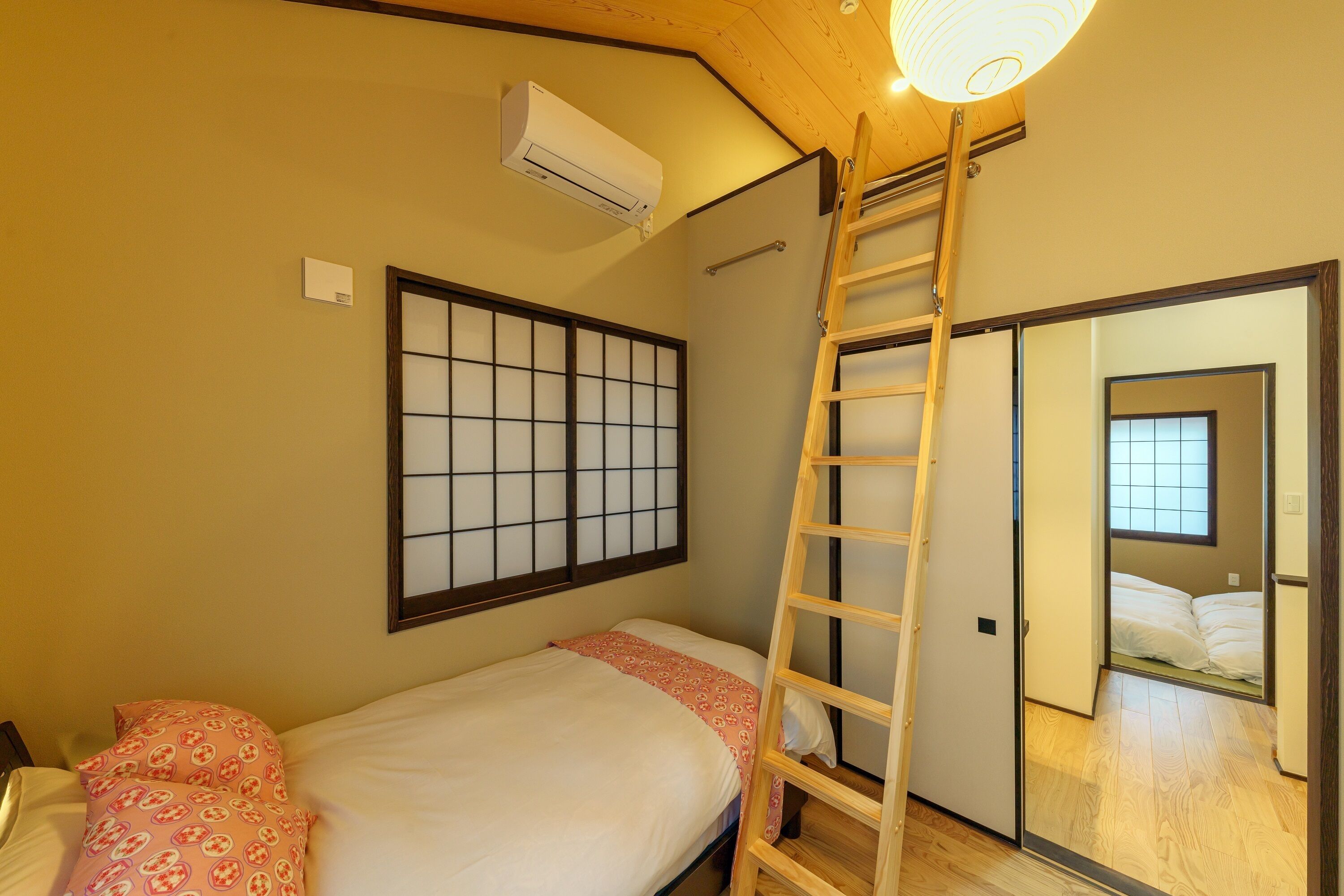 A bedroom with a bed, a ladder, a sliding door, and a shoji screen.