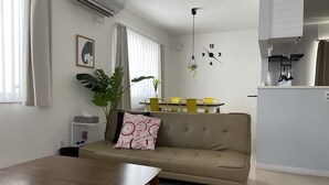 Una sala de estar moderna con un sofá, una mesa de comedor y una zona de cocina.