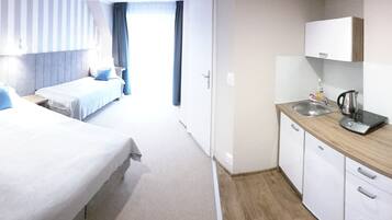 Hotelkamer met een groot bed, een klein bureau, een televisie, een wastafel en een kast.