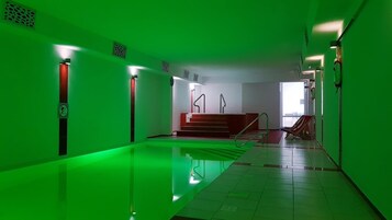 Una piscina techada, sillones reclinables de piscina