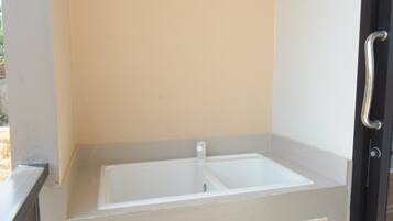 A small bathroom with a white sink and a handrail.