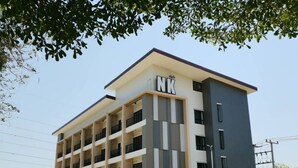 Un edificio de varios pisos con un diseño moderno, que cuenta con balcones en cada planta.