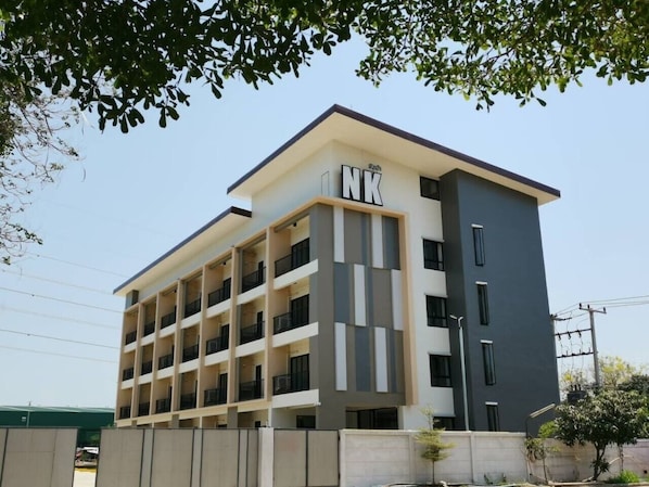 Un edificio de varios pisos con un diseño moderno, que cuenta con balcones en cada planta.