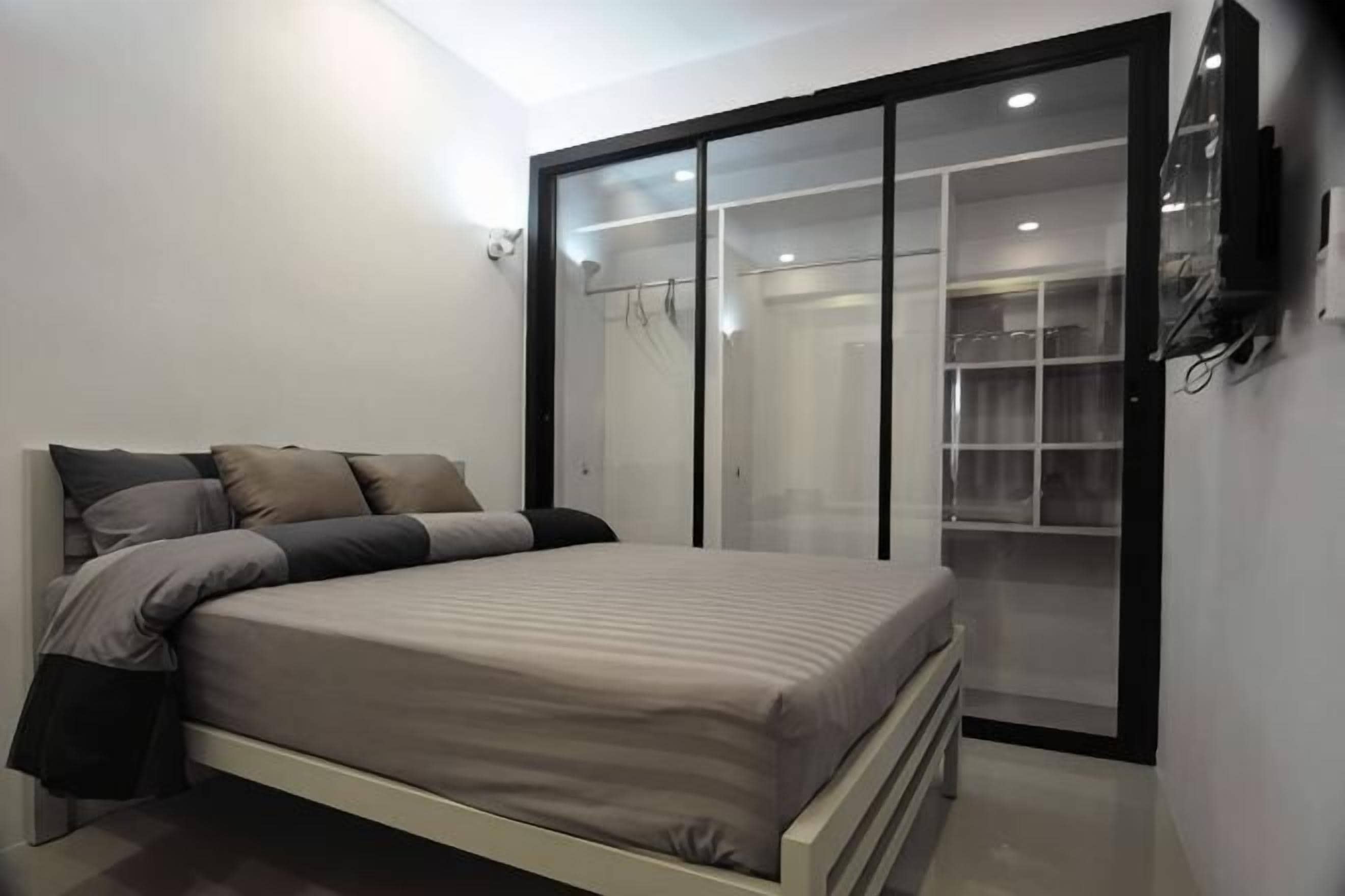 A bedroom with a bed, a wardrobe, and a television.