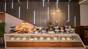 A buffet setup with various dishes and a grill, in a room with a wooden panel wall and a sign reading "Purple Lotus Hotel". - Purple Lotus Hotel (Hai Phong)