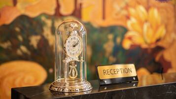 A reception desk with a glass dome clock and a sign labeled "RECEPTION".