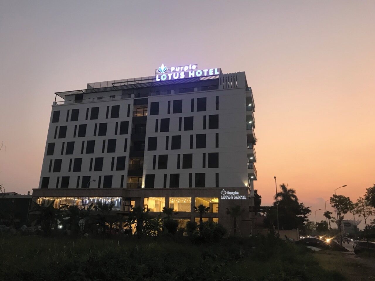 A multi-story hotel with a prominent sign reading 'Purple Lotus Hotel.'