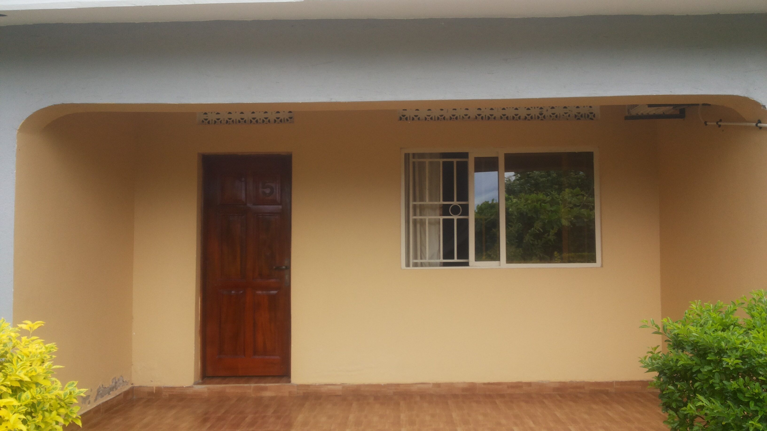A house with a wooden door and a window with bars.