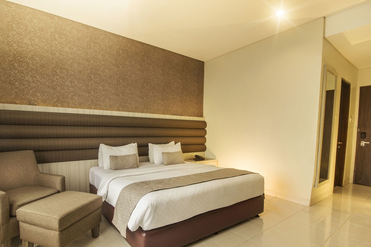 Une chambre d’hôtel avec un lit, une chaise et une table de chevet.