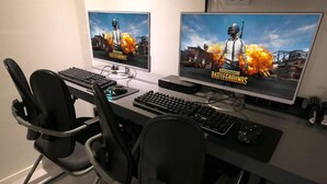 Ein Gaming-Setup mit zwei Monitoren, einer Tastatur, einer Maus und zwei Gaming-Stühlen.