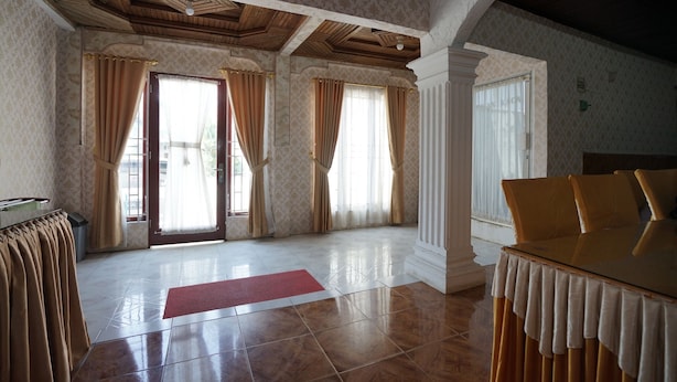 Une pièce spacieuse avec une grande table à manger, un plafond en bois et un papier peint à motifs.
