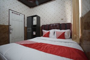 A hotel room with a bed, a wardrobe, and a door. - Hotel O Silampari (Lubuklinggau)