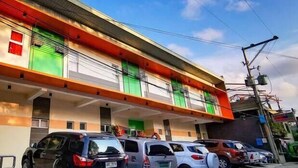 A multi-story building with a flat roof and a parking area in front. - Downtown Suites (Cagayan de Oro)