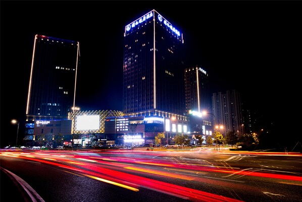A nighttime cityscape with illuminated buildings and a busy intersection. - New Century Life Hotel Changchun (Changchun)