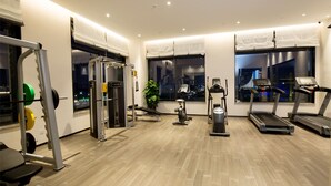 A modern gym with various exercise equipment, large windows with city views, and a clean, well-lit interior. - New Century Life Hotel Changchun (Changchun)