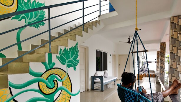 Um interior moderno com escada, rede e um banco.