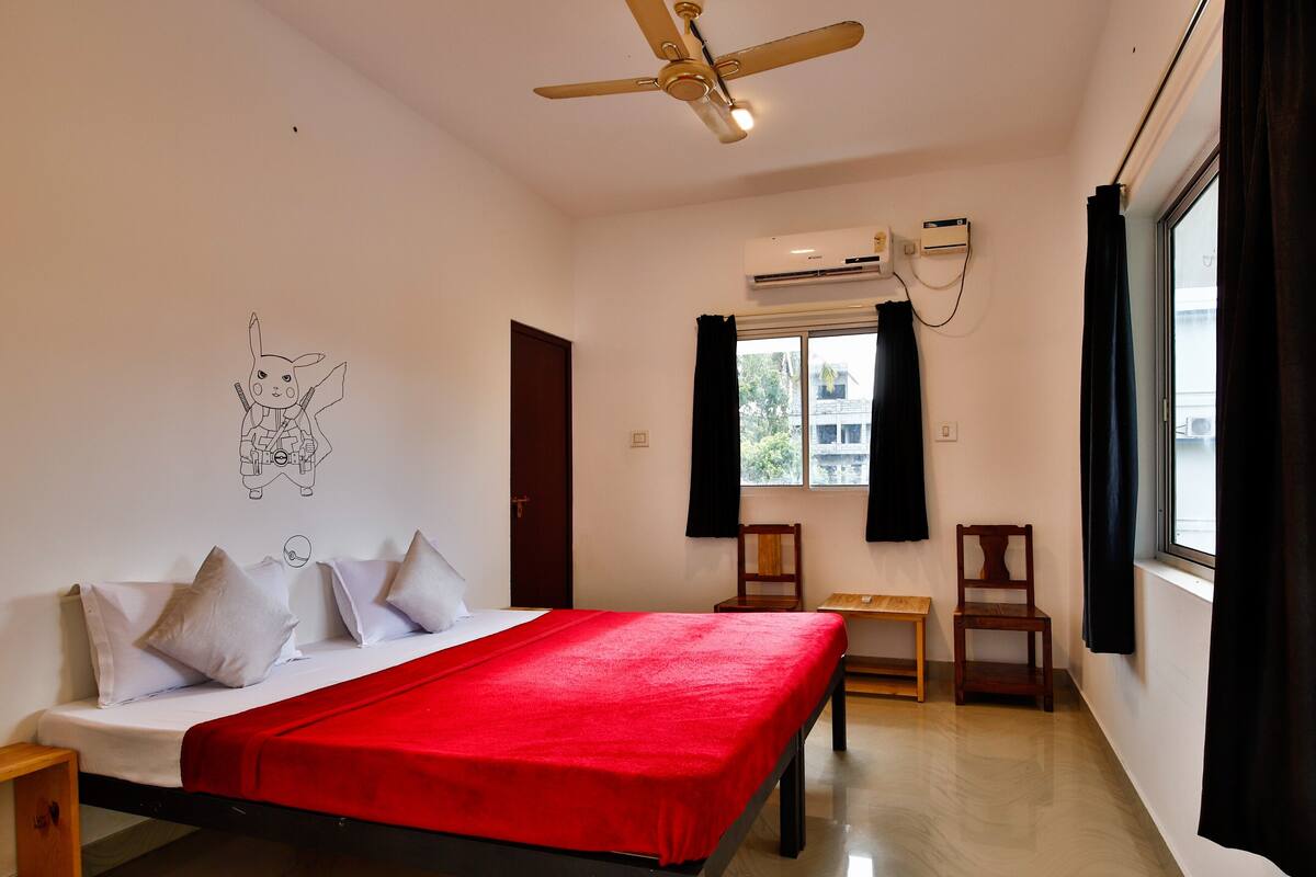Ein Schlafzimmer mit Bett, Deckenventilator, Klimaanlage, einem Fenster mit Vorhängen und einer Wandsticker.