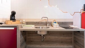 A modern kitchen with a wooden countertop, stainless steel sink, and a tiled backsplash.