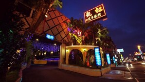 A hotel with a distinctive pyramid-shaped roof and illuminated signage. - Kai-Hong Motel (Taoyuan City)