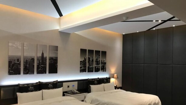 A modern hotel room with two beds, a cityscape view, and a dark accent wall. - Kai-Hong Motel (Taoyuan City)