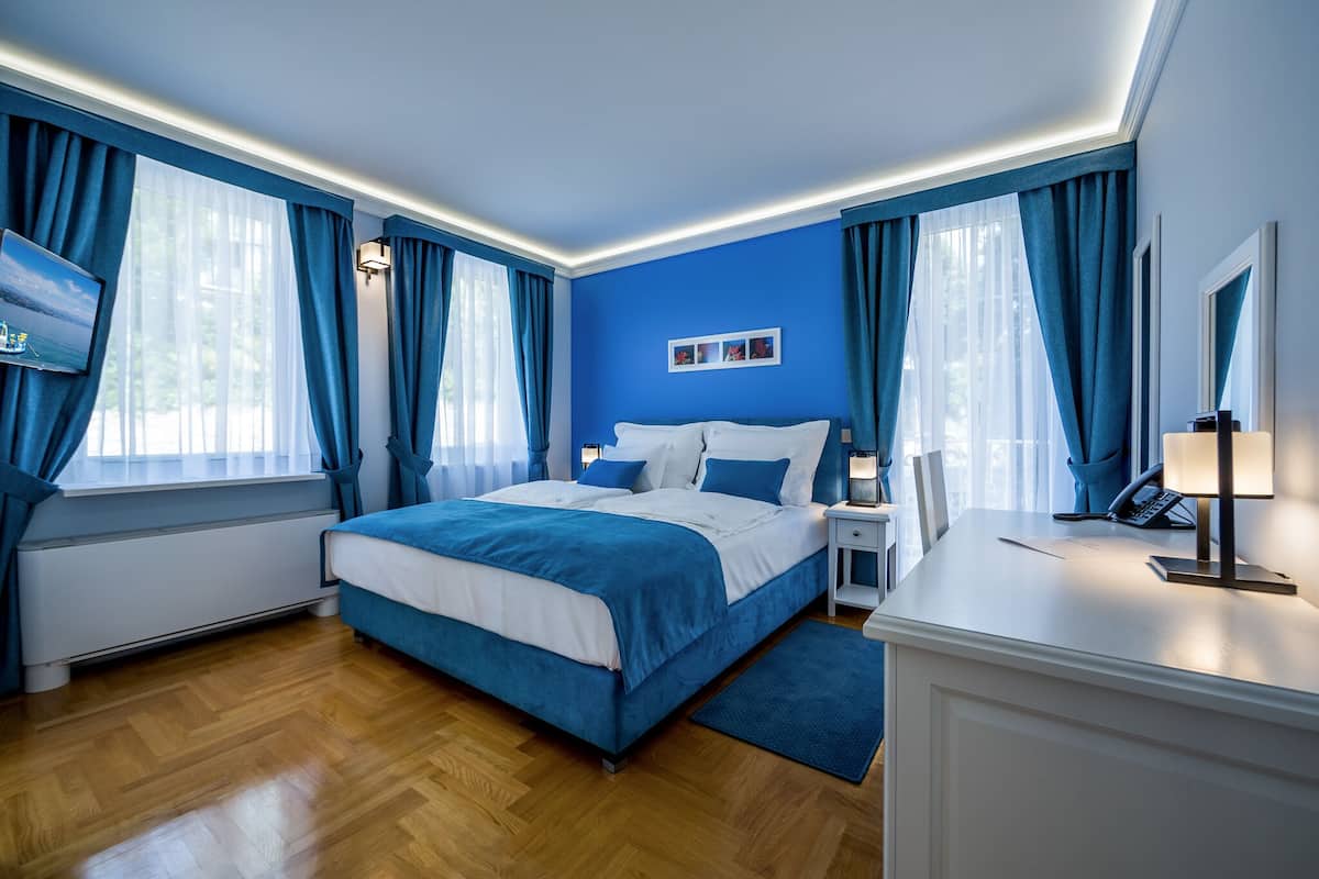 Ein modernes Hotelzimmer mit einem großen Bett, einem Schreibtisch und einem Fernseher.
