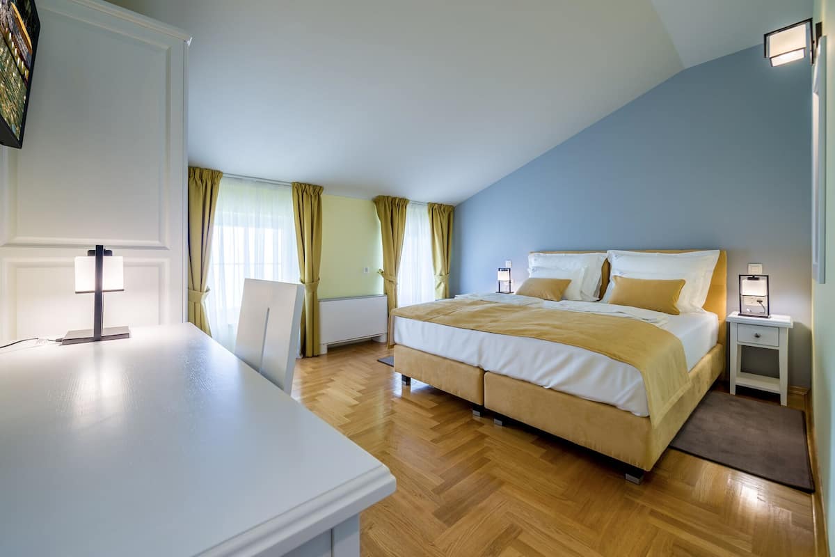 Ein Schlafzimmer mit einem Bett, Nachttischen, einem Schreibtisch und einem Stuhl.