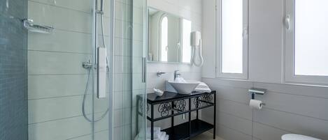 A modern bathroom with a glass shower enclosure, a vanity with a sink and mirror, and a toilet.
