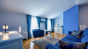 Una sala moderna con un sofá azul, una mesita y un televisor.