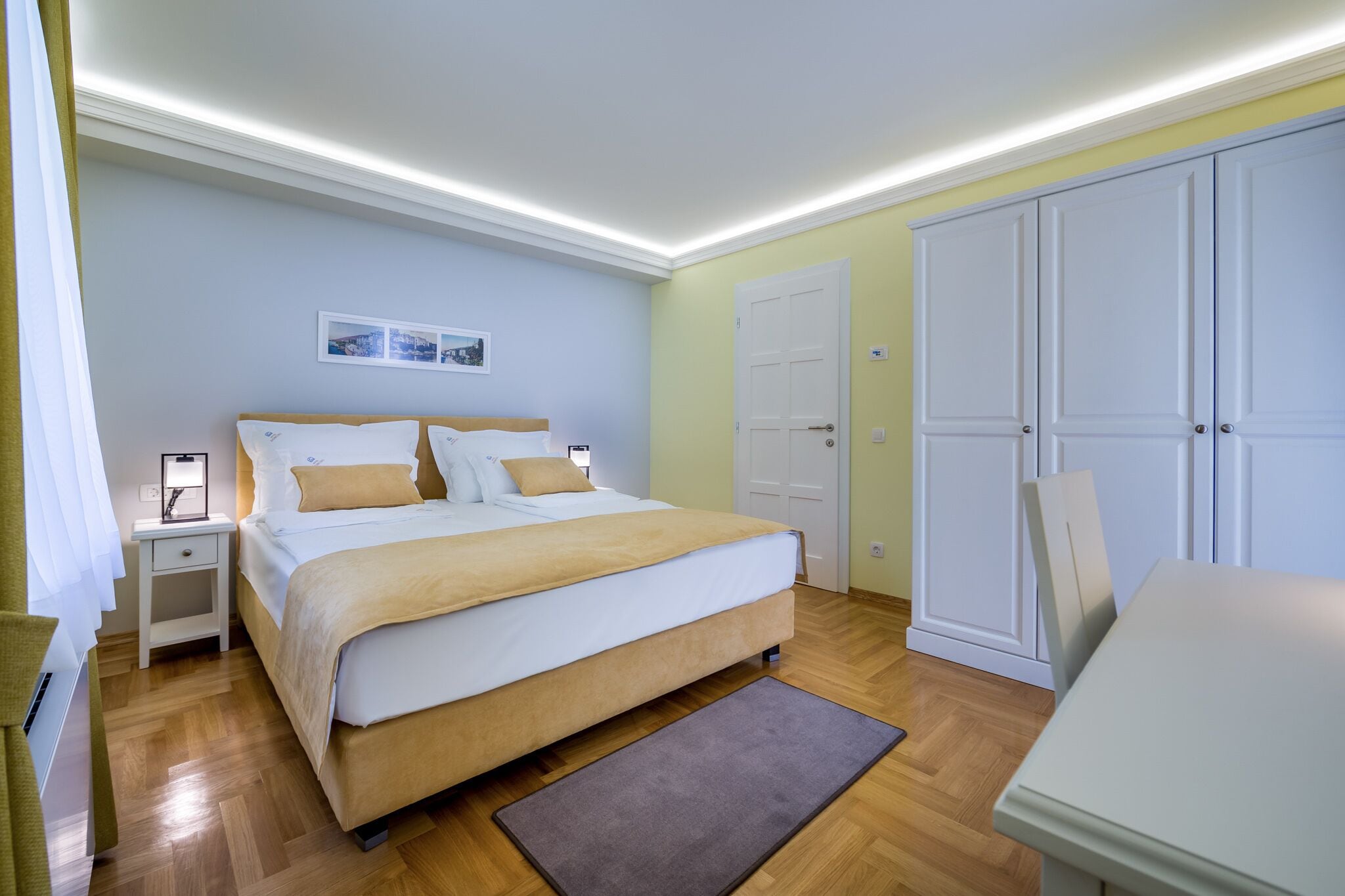 Un dormitorio con cama, mesitas de noche, escritorio y armario.