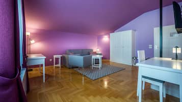 Een kamer met paarse muren, een bed, een bureau, een stoel en een kledingkast.