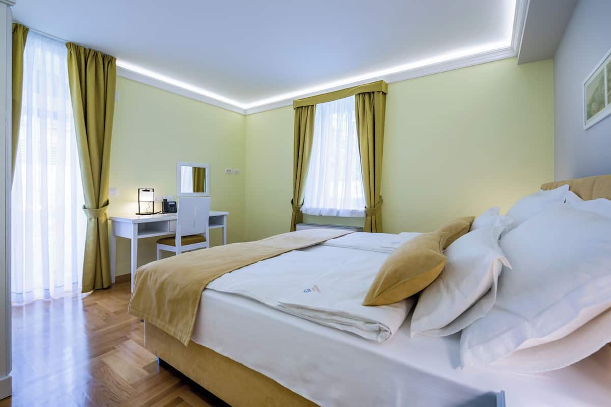 Ein Hotelzimmer mit Bett, Schreibtisch und Stuhl.
