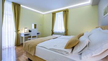 Quarto de hotel com cama, escrivaninha e cadeira.