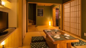 Et traditionelt japansk rum med tatamimåtter, et lavt spisebord og en skydedør med shoji-skærm.