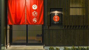 En restaurantindgang med rødt gardin, et logo og et skilt, der angiver, at det er Yadoya.