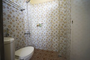 A bathroom with patterned tiles, a toilet, and a shower area. - OYO 1146 Miracle Homestay Syariah (Palembang)