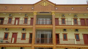 A multi-story building with balconies, large windows, and decorative moldings. - OYO 1146 Miracle Homestay Syariah (Palembang)