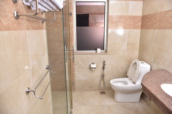 Un baño con ducha de vidrio, inodoro y lavamanos.