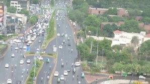 Una concurrida vía urbana con múltiples carriles y vehículos.