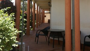 A hotel with a covered outdoor area, columns, and outdoor seating. - Zawadi Hotel (Adjumani)