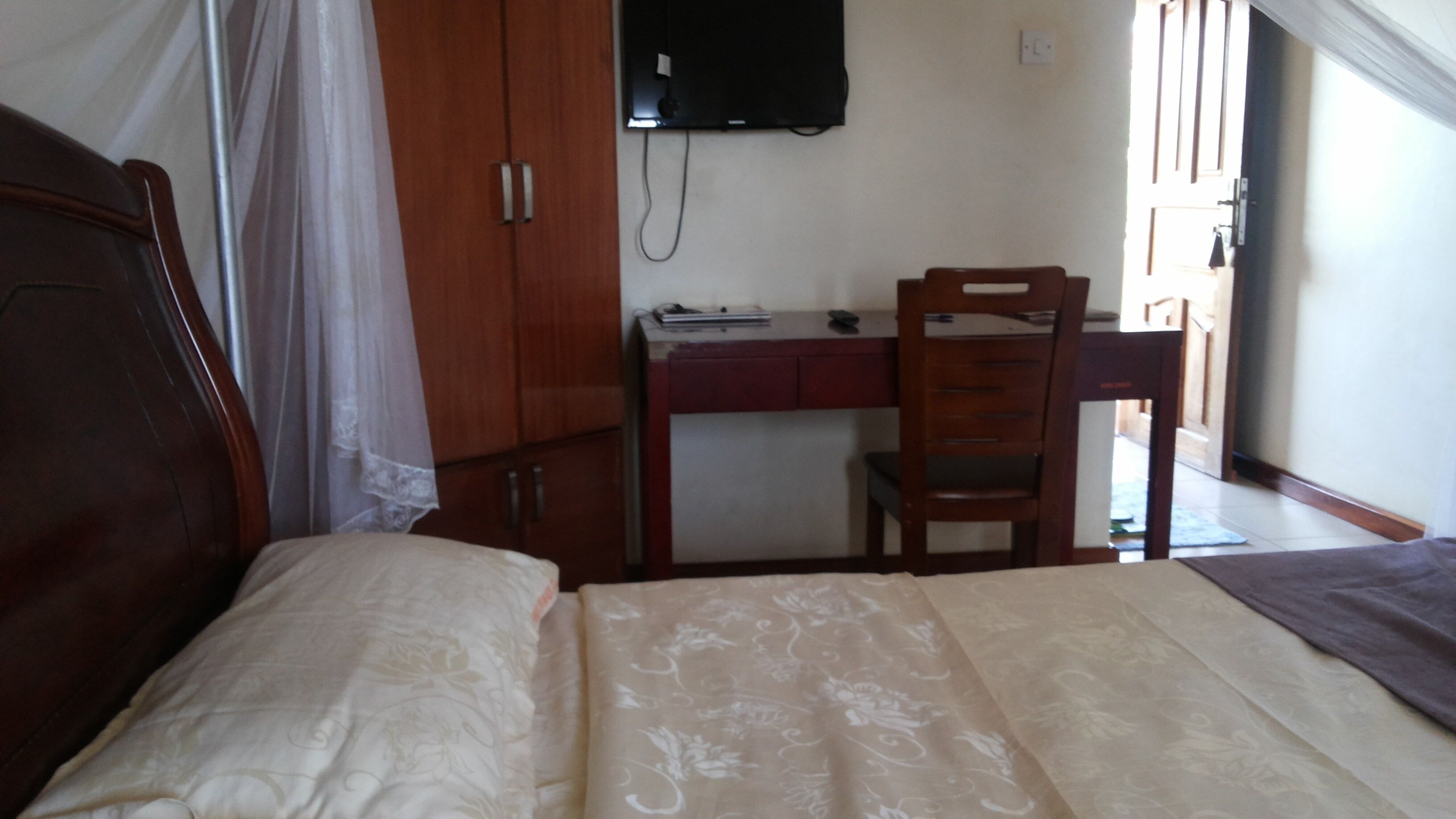 A bedroom with a bed, a desk, and a chair.