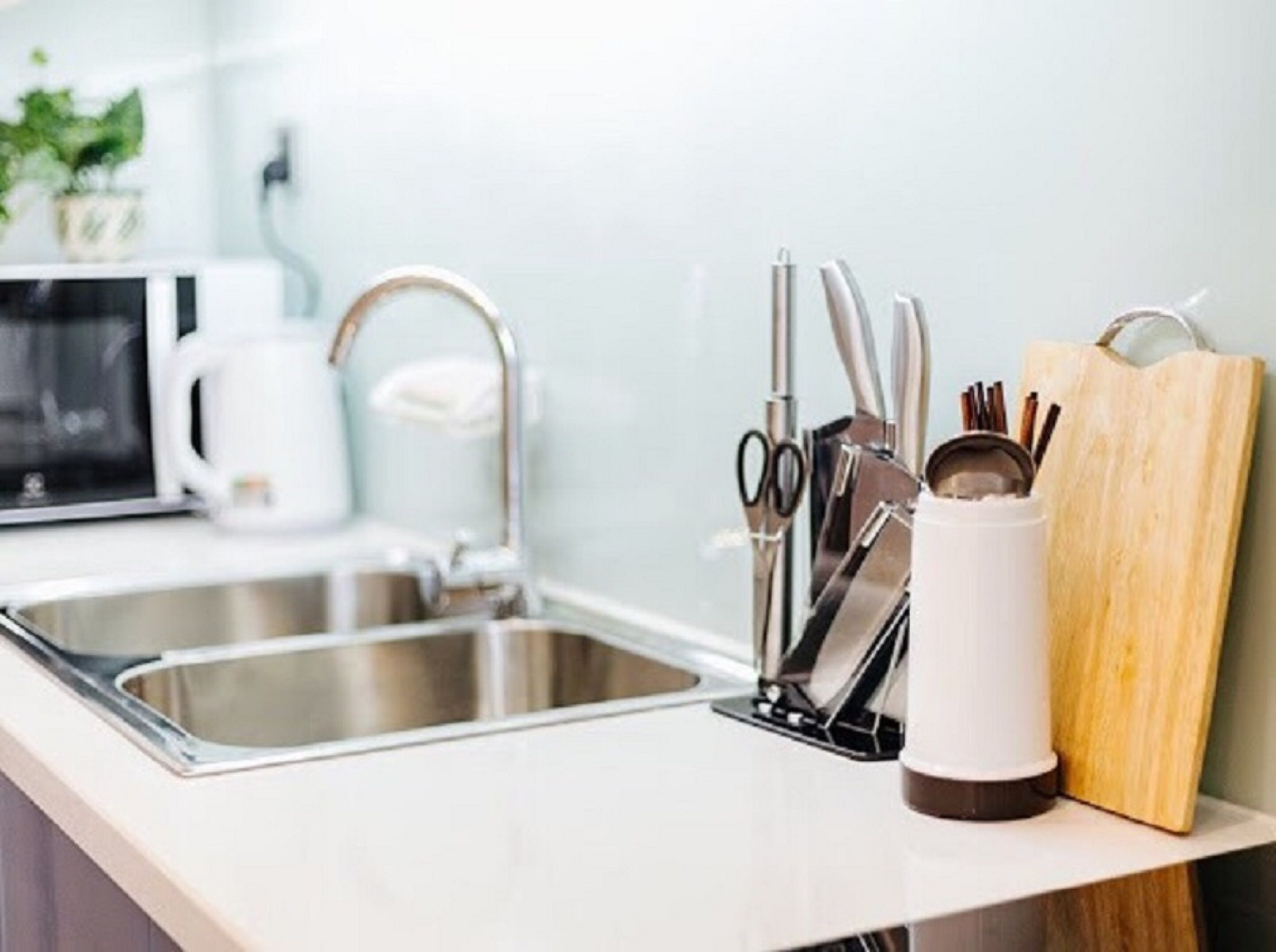 A modern kitchen with stainless steel appliances, a sink, and various utensils.