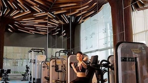 A gym with exercise equipment, large windows, and a modern ceiling design. - Vinhomes Green Bay Apartments (Hanoi)